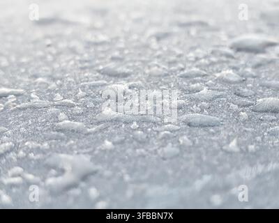 A close-up, macro photograph of an ice or frost surface showing intricate crystalline textures. The image features a shallow depth of field with Stock Photo