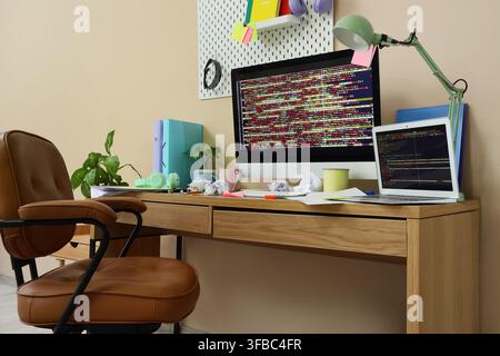 Remote work and coding stress messy home office desk with computer laptop and crumpled papers Stock Photo