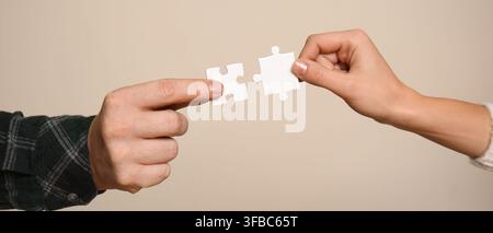 Teamwork and collaboration concept, two hands connecting puzzle pieces, problem solving and partnership strategy Stock Photo