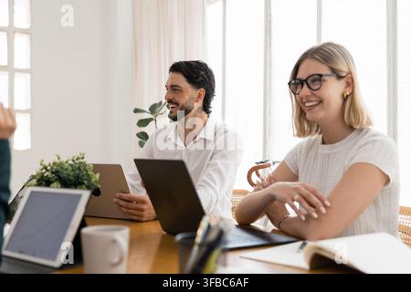 Business people collaborating and laughing during office meeting Stock Photo