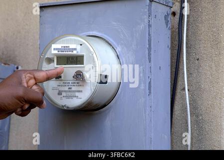 Technician checking side profile of home digital electric smart meter. Stock Photo