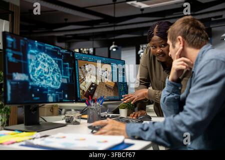 Multiethnic team of experts using artificial intelligence to design a floor plan, working together with neural networks and computer aided apartment layout on architectural software. Stock Photo