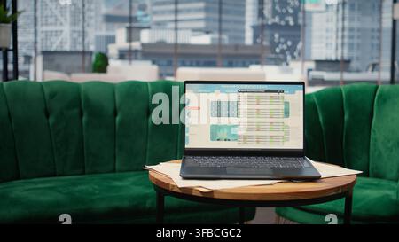 Big data reports and graphics showcasing business corporation success, empty luxurious office with a laptop on the table. Professional workspace with pc display running trends. Stock Photo