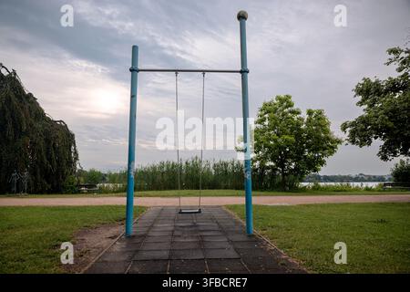 Empty swing overlooking the Alster lake and waterfront parkland in Hamburg, Germany. Stock Photo