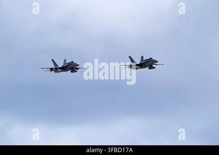 Two military jets flying in formation against cloudy sky. Stock Photo