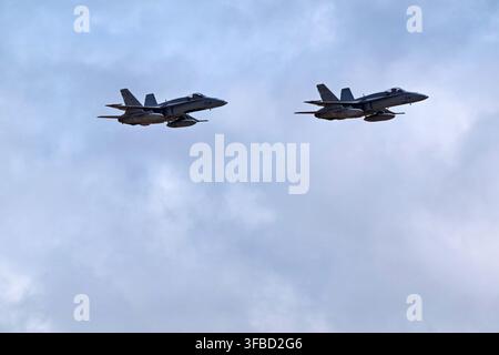Two military fighter jets flying in formation against a cloudy sky. Stock Photo