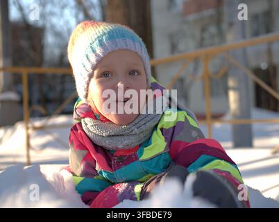 Smiling girl bundled up in winter clothing in the snow Stock Photo