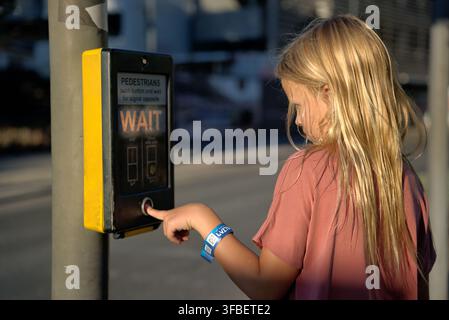 Girl pressing pedestrian crossing button in Gibraltar street Stock Photo