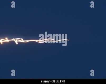 Light trail streak with motion blur against a dark blue sky Stock Photo