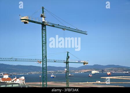 Eurogruas tower cranes above sea with cargo ships Stock Photo