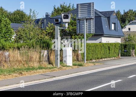 Wallonia, Belgium: Speed radar camera mounted on a roadside pole near residential houses for enforcing vehicle speed limits. Stock Photo
