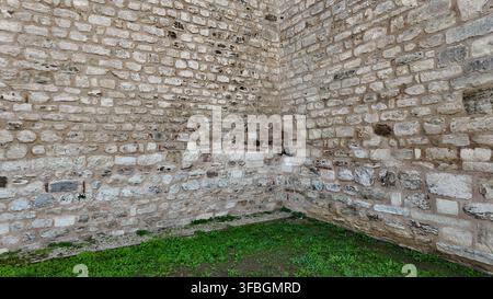 Old stone wall in a grassy area Stock Photo
