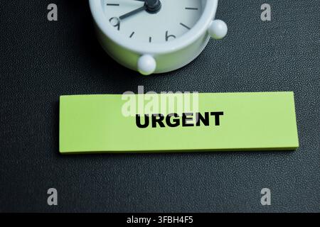 Concept of urgent write on sticky notes isolated on table. For work deadline management Stock Photo