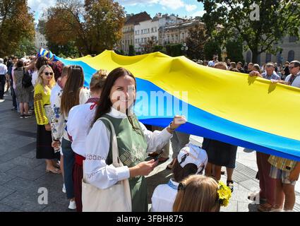 Ukrainians hold national flag a 35-meter long during a public event to mark National Flag Day in Lviv, western Ukraine, 23 August 2026. National Flag Day is celebrated annually in Ukraine on 23 August, honoring one of the country's main state symbols. Stock Photo