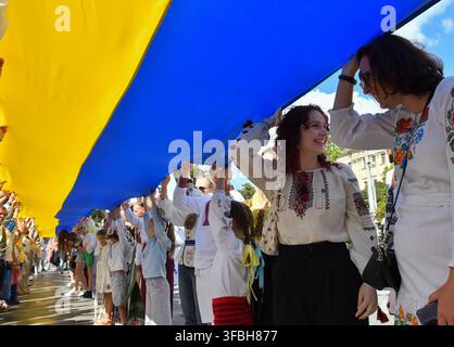 Ukrainians hold national flag a 35-meter long during a public event to mark National Flag Day in Lviv, western Ukraine, 23 August 2026. National Flag Day is celebrated annually in Ukraine on 23 August, honoring one of the country's main state symbols. Stock Photo