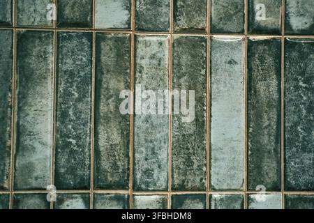 A pattern of modern vertical rectangular malachite tiles. Realistic texture. The walls are lined with green ceramic tiles with space for copying. Stock Photo
