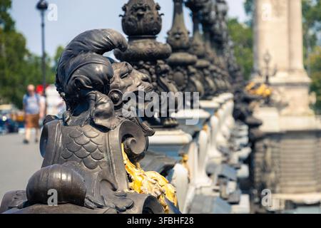 Detailed view of historical black iron fence with golden elements on pont alexandre III against blurred background Stock Photo