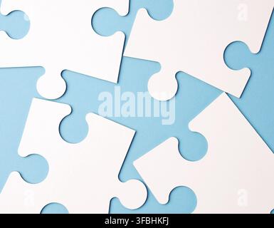 Empty white big puzzles on a blue background. Concept in business, close up Stock Photo