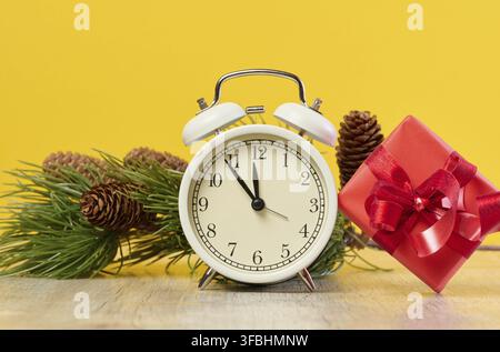 Alarm clock and stack of red gift boxes on yellow background Stock Photo