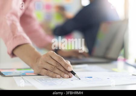 Graphic designers team work together with UX UI designer planning application template layout mobile phone prototype, User experience concept Stock Photo