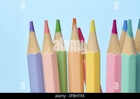 Multicolored wooden pencils sharpened on blue background, school supplies Stock Photo