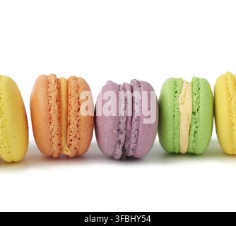 Multi-colored round baked macarons cakes on a white isolated background, dessert stands in a row, close up Stock Photo