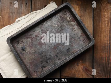Empty rectangular iron rusty baking sheet on a wooden brown table, top view Stock Photo