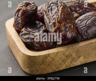 Ripe large dates in a wooden plate Stock Photo