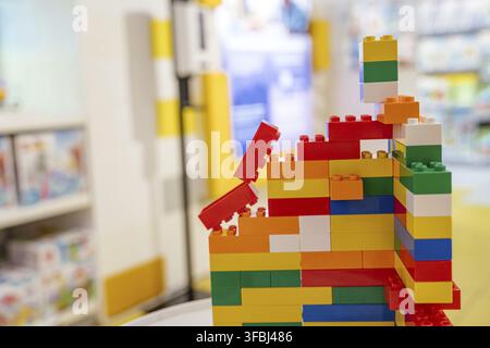 A vibrant structure built from colorful plastic constructor blocks stands on display in a toy store. Bright colors and soft focus in the background cr Stock Photo
