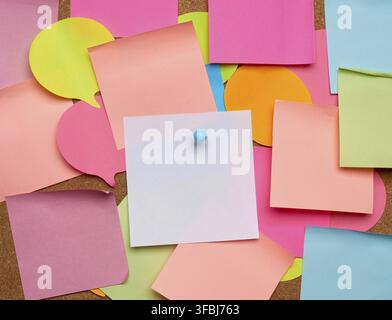 Colorful paper stickers glued on brown balsa board, idea and multitasking, close up Stock Photo