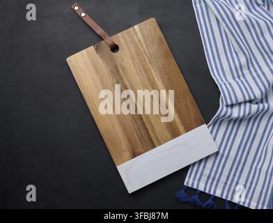 Empty rectangular wooden kitchen cutting board on black table top view Stock Photo