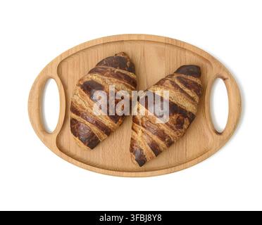 Two baked croissants lie on a wooden tray, food isolated on white background, top view Stock Photo