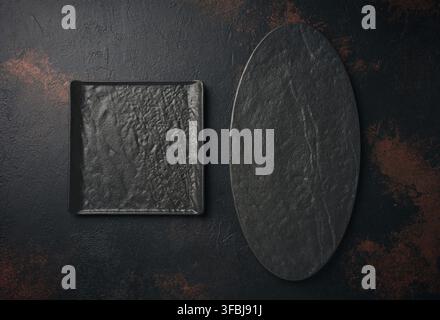Oval and square stone kitchen board on black background, top view Stock Photo