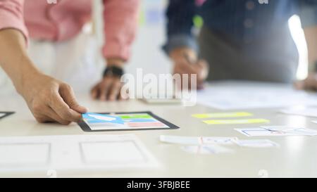 Graphic designers team work together with UX UI designer planning application template layout mobile phone prototype, User experience concept Stock Photo