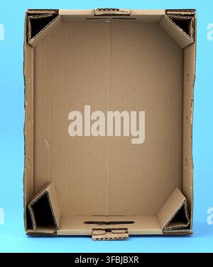 Rectangular empty cardboard box of brown paper on a blue background, box without a lid for vegetables and fruits in with holes Stock Photo