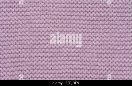 Knitted fabric made of pink wool threads, pigtail pattern, full frame. Close up Stock Photo
