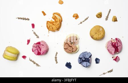 Broken round macarons with crumbs on a white background, delicious dessert, top view Stock Photo
