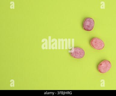 Fruit oval lollipops isolated on a green background, copy space Stock Photo