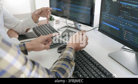 Young startup Programmers Sitting At Desks Working On Computers screen for Developing programming and coding to find solution to problem on New Applic Stock Photo