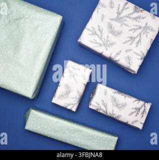 Various boxes packed in paper on a blue background, holiday gifts, top view Stock Photo