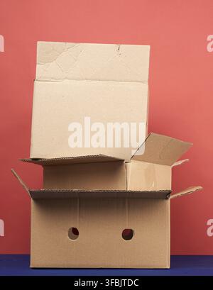 Stack of cardboard boxes of brown kraft paper on a wooden table, moving concept Stock Photo