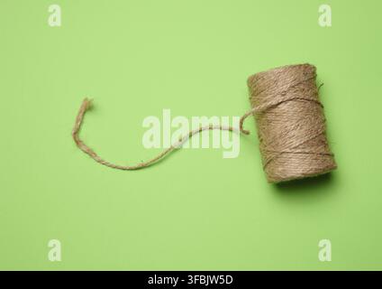 Brown thread spool on a green background, packaging rope Stock Photo