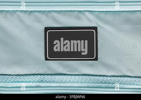 Black rubber blank patch stitched on light blue fabric background Stock Photo