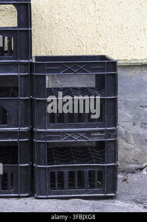 Stack of empty black plastic crates for glass bottles Stock Photo