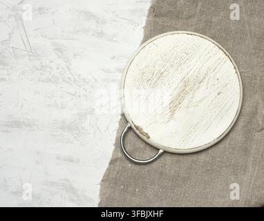 Empty round small cutting board lie on a white background, top view Stock Photo
