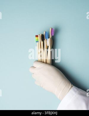 Multicolored wooden toothbrushes on a blue background, plastic rejection concept, zero waste Stock Photo