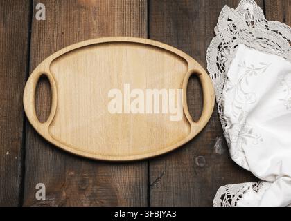 Empty oval brown wooden tray board on a wooden background, top view Stock Photo