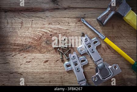 Set of Hand tools on a dark rustic wooden background, working tools, hammer screwdriver, screws and hinges, top view. Nobody, copy space for text Stock Photo
