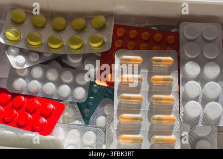 First aid kit with bright vitamins and pills under warm sunlight, symbolizing daily health care, energy, and disease prevention. Stock Photo