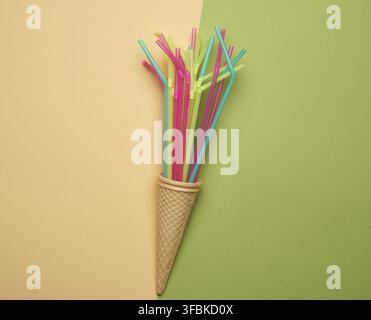 Stack of plastic multi-colored cocktail tubes on a green background, close up Stock Photo